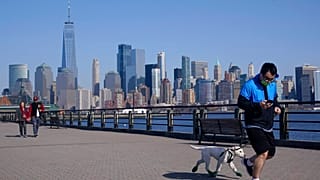 people enjoy the warming weather and a view of lower Manhattan at Liberty State Park in Jersey City