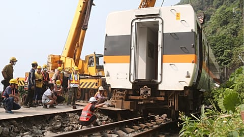 Workers try to remove a part of the derailed train near Taroko Gorge in Hualien, Taiwan 