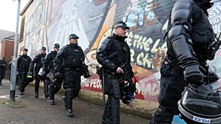 FILE: Riot police leave the area after policing a parade by the unionist Orange Order at the Ardoyne shops on the Crumlin Road in north Belfast on October 1, 2016.