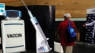 A man leaves after he received Pfizer's COVID-19 vaccine at the Saint Quentin en Yvelines velodrome, now a vaccination site, outside Paris, Wednesday, March 24, 2021