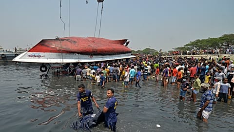 Divers carry a dead body after recovering from the capsized boat in Shitalakshya River, in Narayanganj.