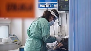 A medical worker attends to a patient suffering from COVID-19 in the emergency ward at the hospital in Bochnia.
