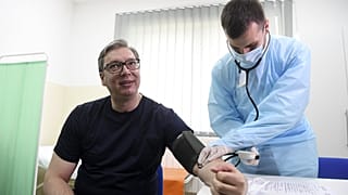 Serbian President Aleksandar Vucic, left, has his blood pressure taken before receiving a shot of the Chinese Sinopharm vaccine in the village of Rudna Glava, Serbia.