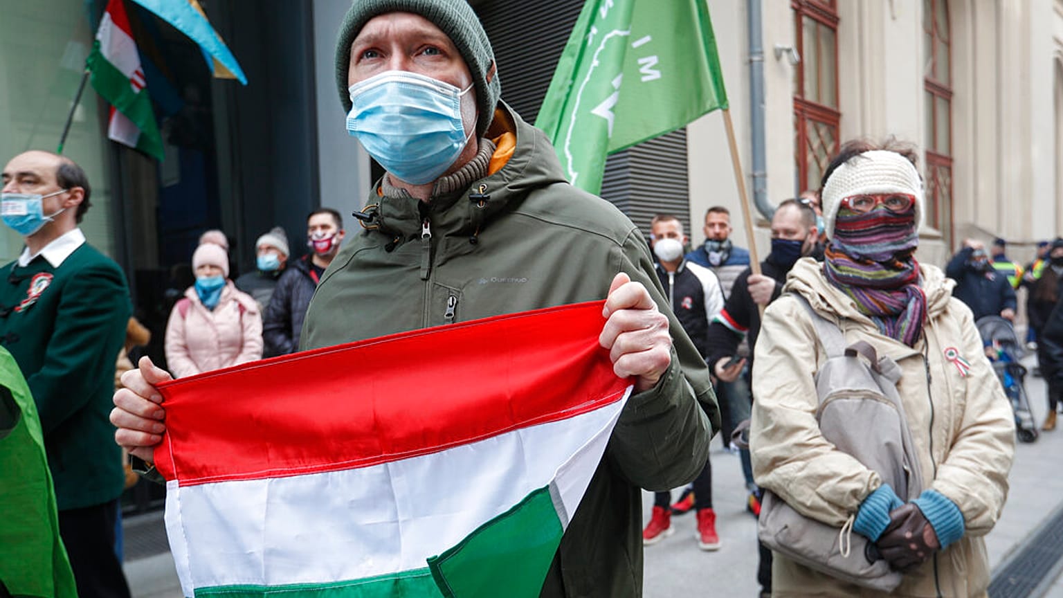 A man holds a Hungarian flag during a protest in Budapest, Hungary, Monday, March 15, 2021. 