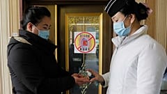 A staff member, right, of the Pongnam Noodle House disinfects the hands of a woman coming into its restaurant in Pyongyang, North Korea.