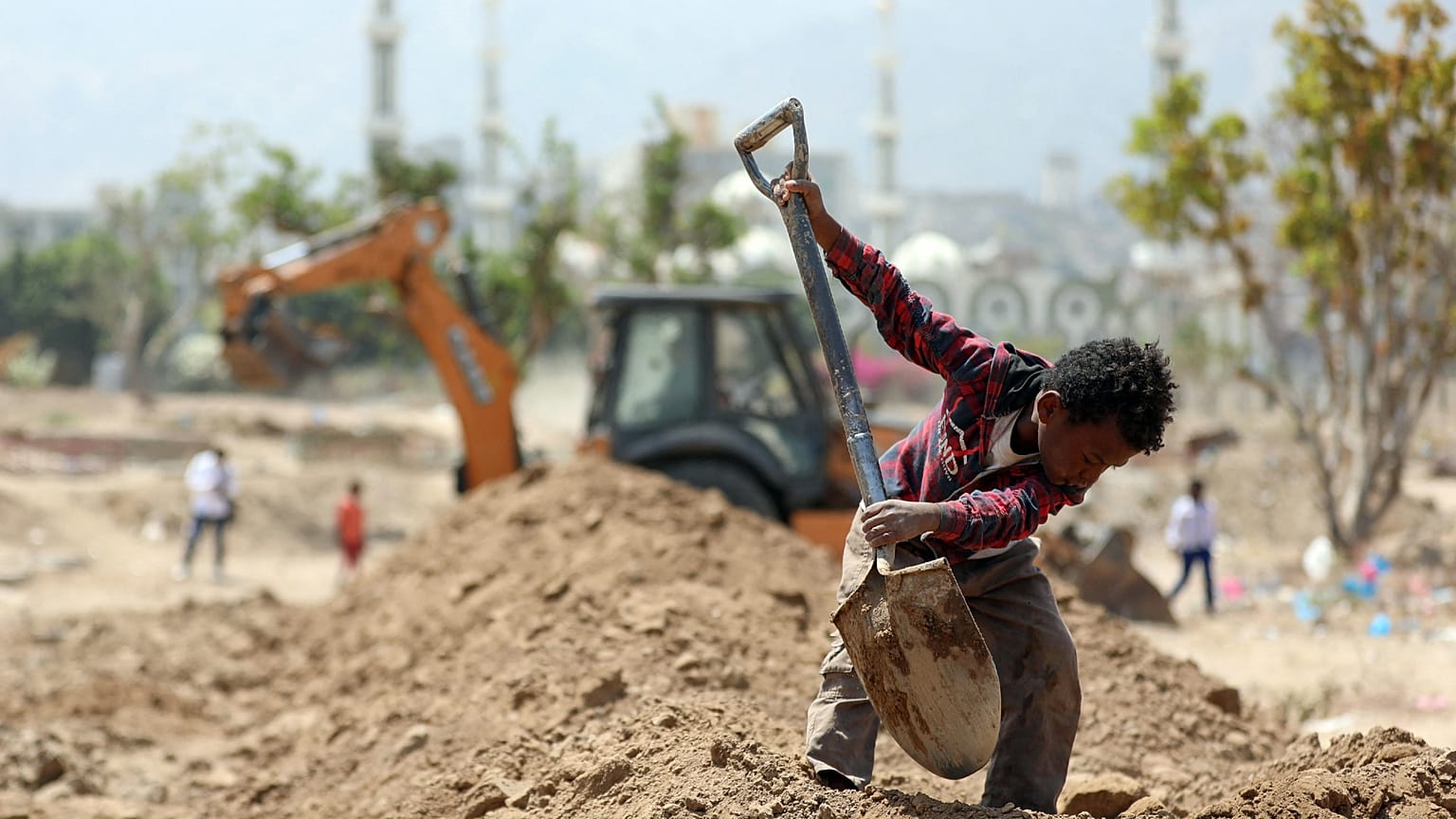 Yemen'de mezar kazmaya yardım eden bir çocuk