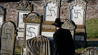 In this Dec. 4, 2019 file photo, Strasbourg chief Rabbi Harold Abraham Weill looks at vandalized tombs in the Jewish cemetery of Westhoffen, west of the city of Strasbourg.