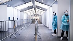 Miembros del personal esperan para administrar las pruebas, en el nuevo centro COVID-19 en Faelledparken, Copenhague, el lunes 29 de marzo de 2021. 