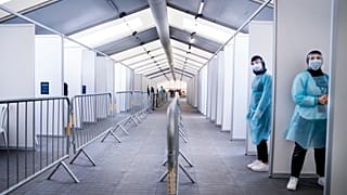 Miembros del personal esperan para administrar las pruebas, en el nuevo centro COVID-19 en Faelledparken, Copenhague, el lunes 29 de marzo de 2021.