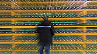 A technician inpsects the backend of a bitcoin mine.