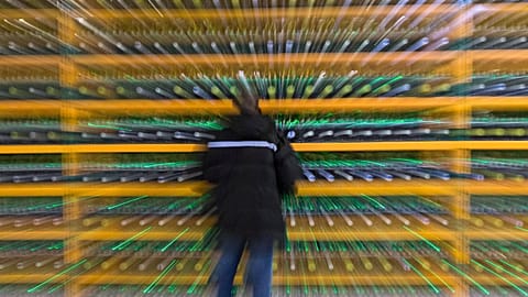 A technician inpsects the backend of a bitcoin mine.
