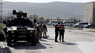 Soldiers stand guard outside the courthouse where 497 defendants are on trial over the failed coup.