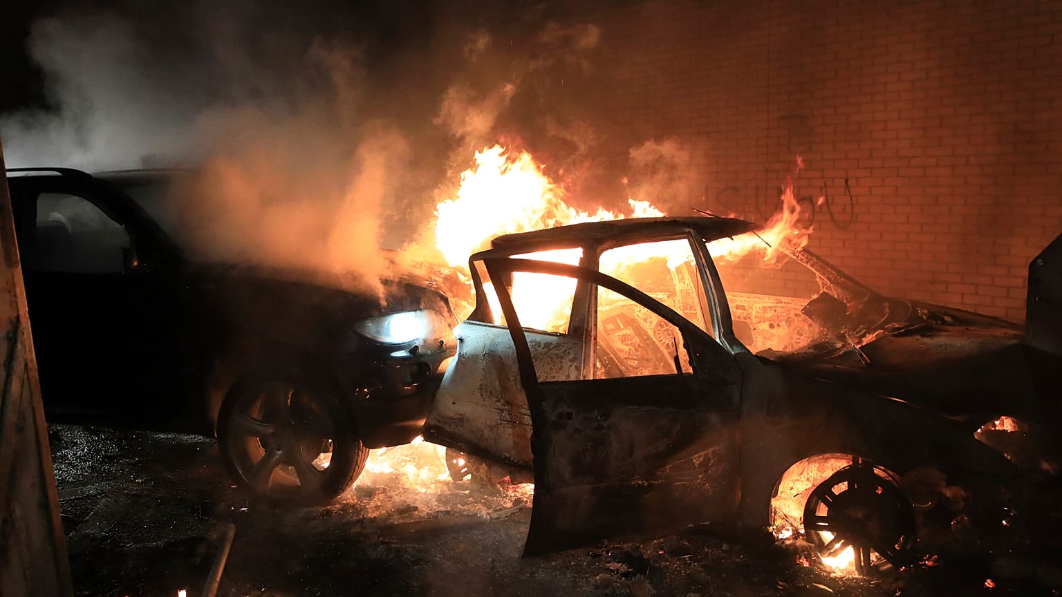 Hijacked cars burn at the peace wall on Lanark Way as rioting broke out in West Belfast, Northern Ireland. April 7, 2021.
