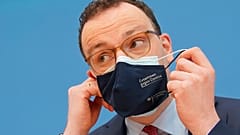 Jens Spahn, Federal Minister of Health, takes off his mouth-nose protection at the Federal Press Conference in Berlin, Germany, Thursday, April 1, 2021.