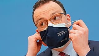 Jens Spahn, Federal Minister of Health, takes off his mouth-nose protection at the Federal Press Conference in Berlin, Germany, Thursday, April 1, 2021.