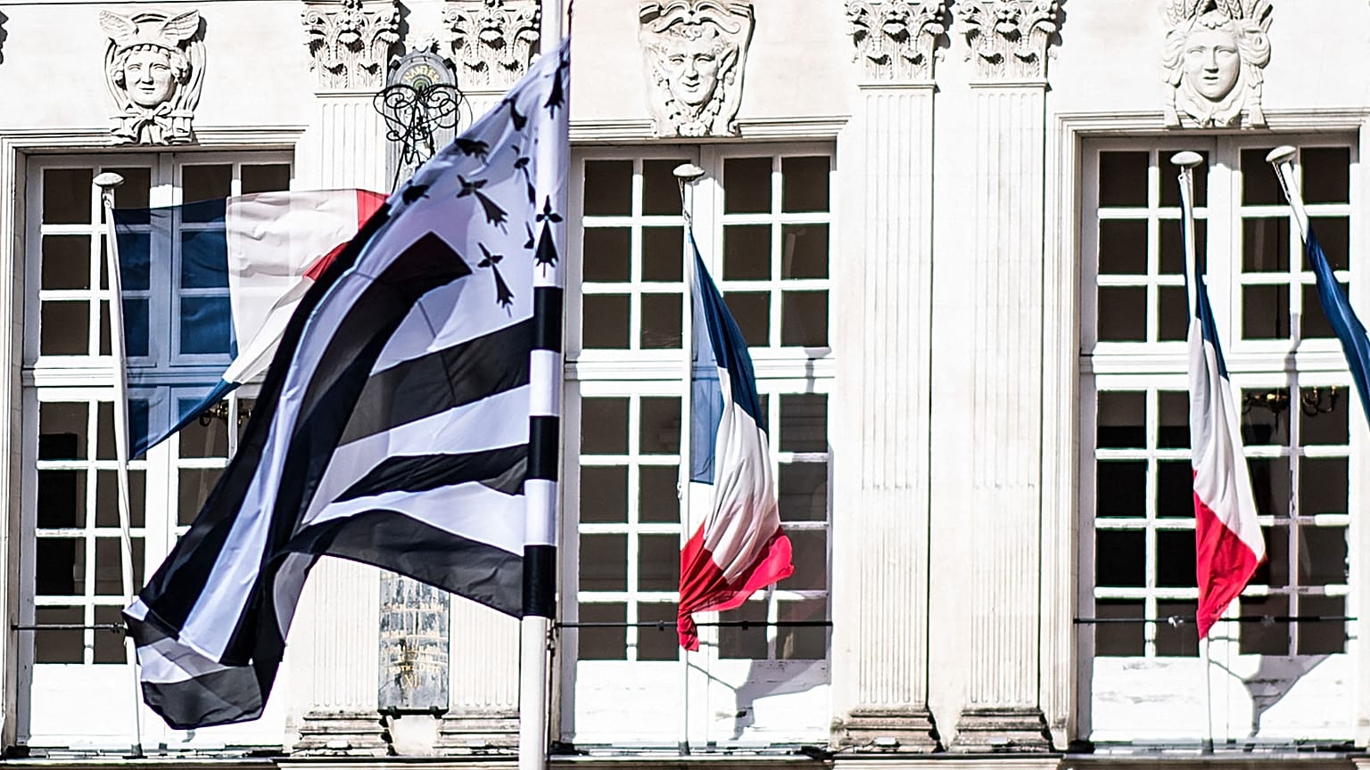 Le "Gwenn ha Du", le drapeau breton et des drapeaux français flottant devant l'hôtel de ville de Nantes, dans l'ouest de la France, le 20 février 2021
