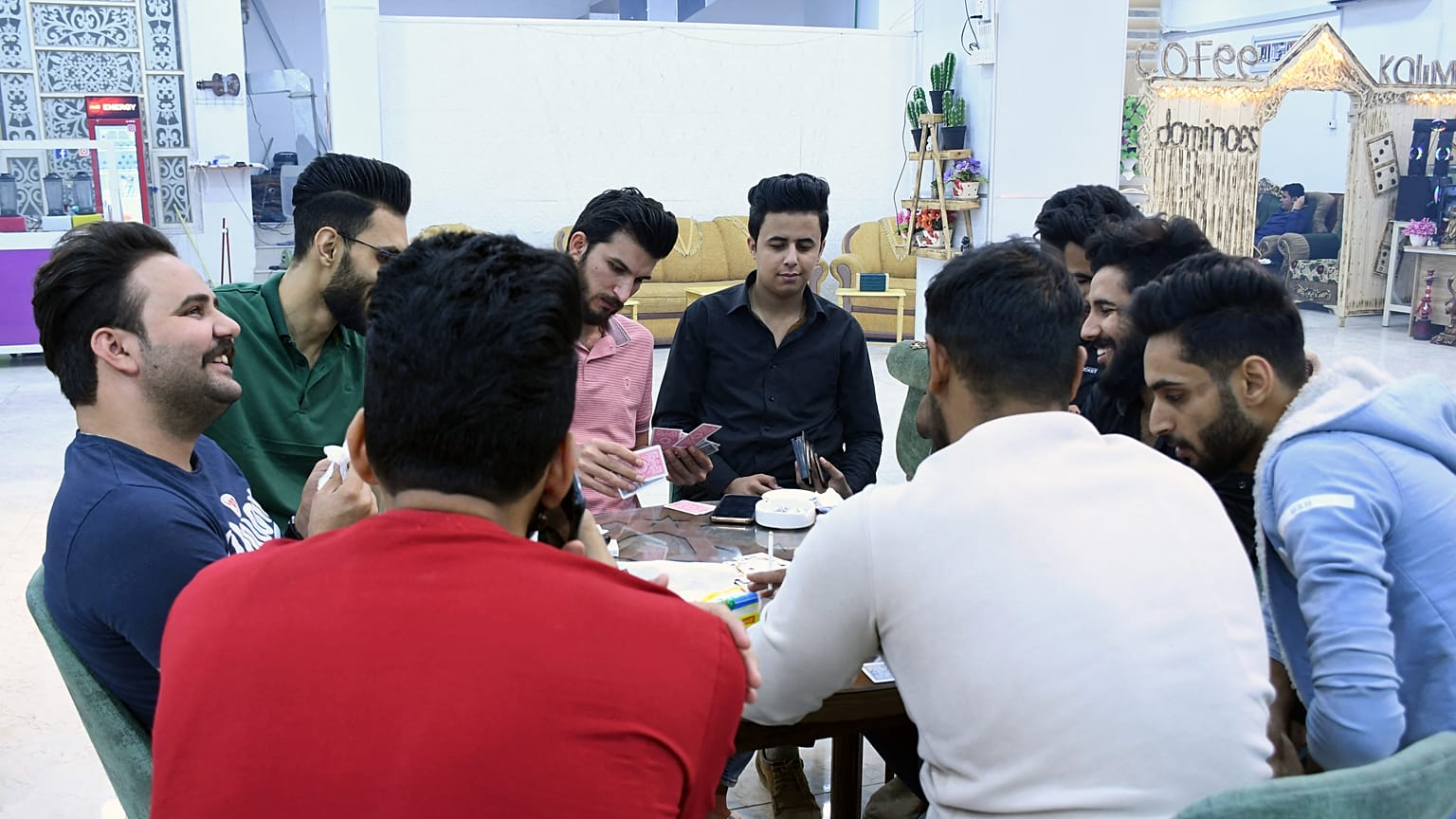 حسين (وسط)، شاب عراقي مع أصدقائه في مقهى، الناصرية، محافظة ذي قار، 4  نيسان / أبريل 2021
