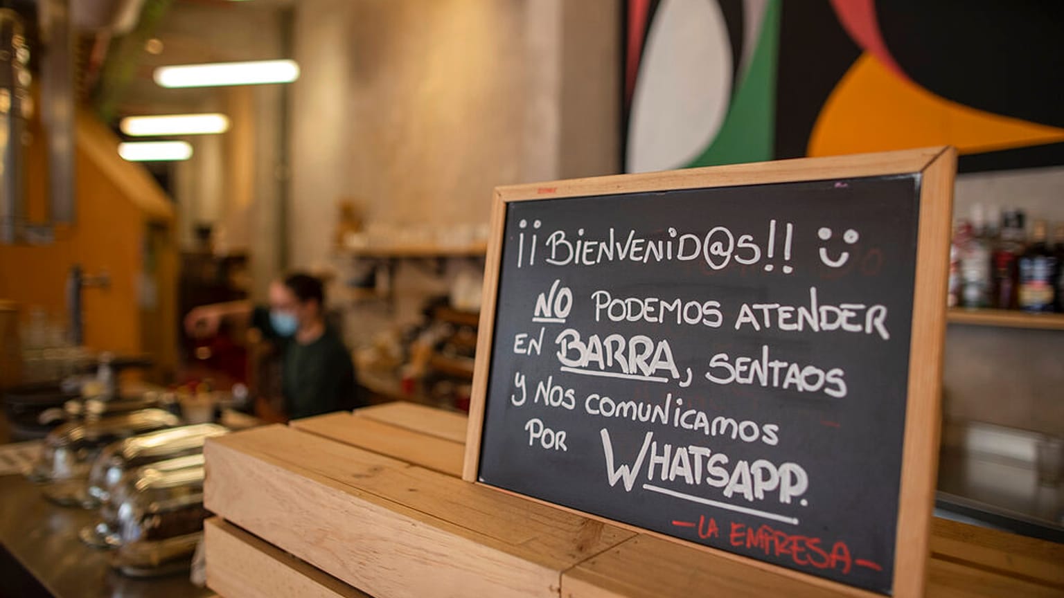 A banner reading in Spanish: "Welcome, we cannot serve in the bar. Sit down and we communicate by WhatsApp" at La Francachela restaurant in Madrid, Spain, March 26, 2021. 