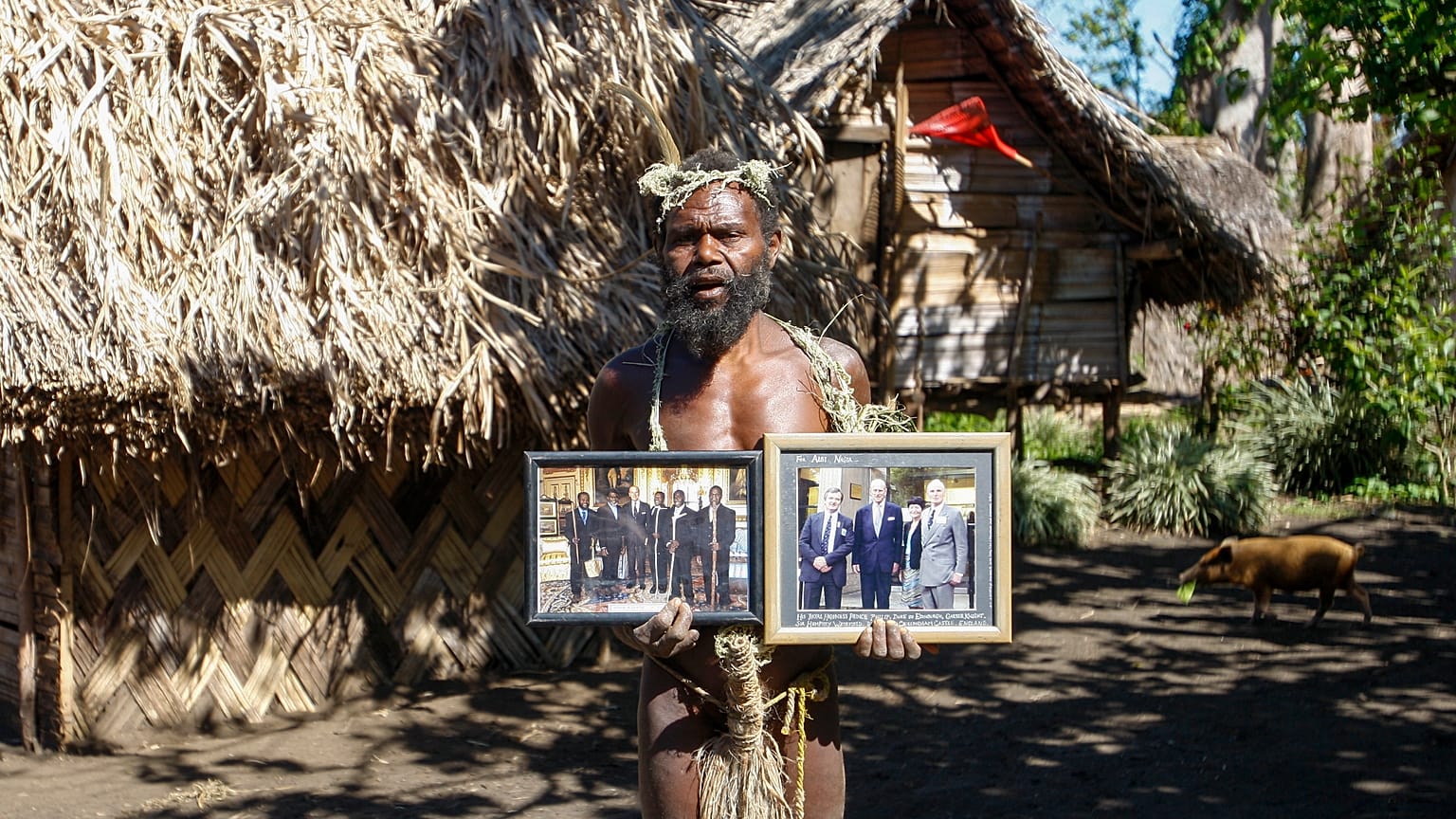 In this Sunday, May 31, 2015 file photo, Albi Nagia poses with photographs of Prince Philip in Yakel, Tanna island, Vanuatu.