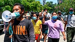 Young demonstrators flash the three-fingered symbol of resistance as they march in Yangon, Myanmar, Saturday, April 10, 2021.