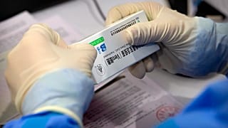 Çinli ilaç firması Sinopharm tarafından geliştirilen Covid-19 aşısını açan bir görevli 