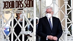 Le président allemand Frank-Walter Steinmeier franchissant le portail d'entrée du camp de concentration nazi de Buchenwald le 11 avril 2021.