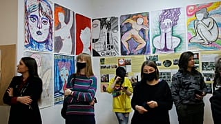 Visitors look at the exhibition of Yulia Tsvetkova's paintings in St. Petersburg, Russia, Saturday, April 10, 2021.