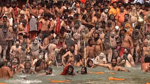 Hindu pilgrims enter Ganges river to bathe during Kumbh Mela gathering