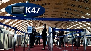 Az Air France földi személyzetének tagjai várják az utasokat a Charles de Gaulle repülőtéren - MTI