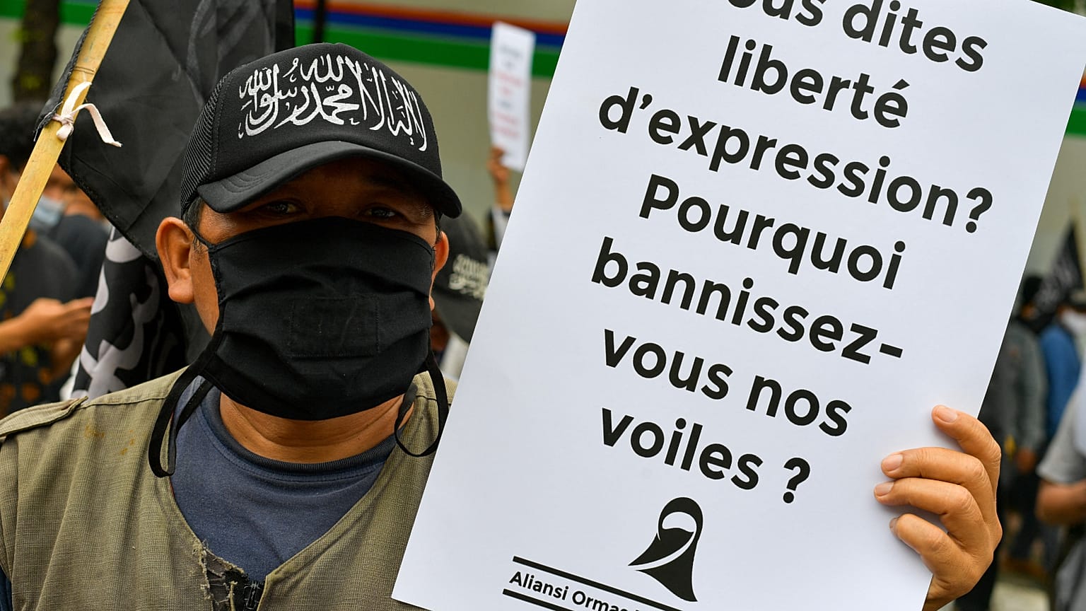 متظاهرون مسلمون يرفعون لافتات خلال مظاهرة مناهضة للرئيس الفرنسي إيمانويل ماكرون.