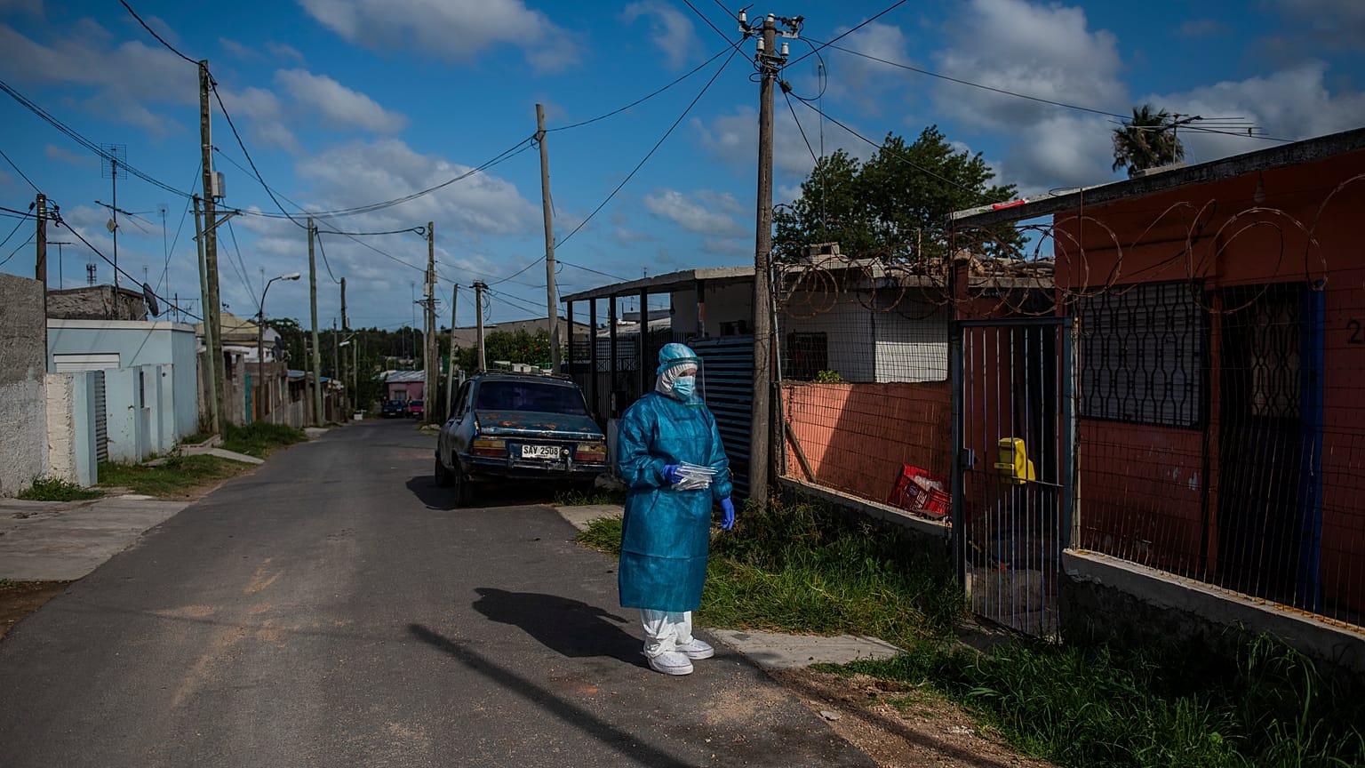 Un sanitario espera antes de hacer un test de covid en un barrio de Montevideo