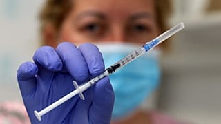 Szputnyik V vakcinát tart a kezében egy miskolci ápolónő