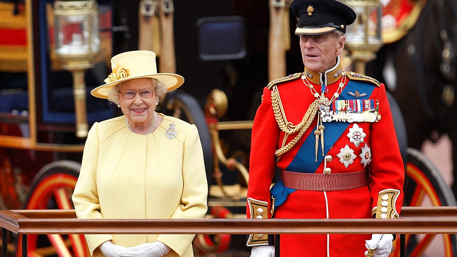 Britain's Queen Elizabeth II, and Prince Philip take a salute as the Guards march past outside Buckingham Palace on June 16, 2012.