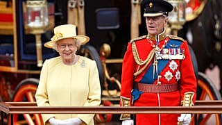 Britain's Queen Elizabeth II, and Prince Philip take a salute as the Guards march past outside Buckingham Palace on June 16, 2012.