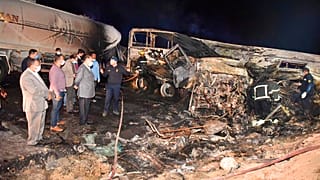 Authorities work on the collision site where a bus overturned, Tuesday