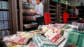 Pénzkötegek rendezgetése egy zürichi bankban (illusztráció)