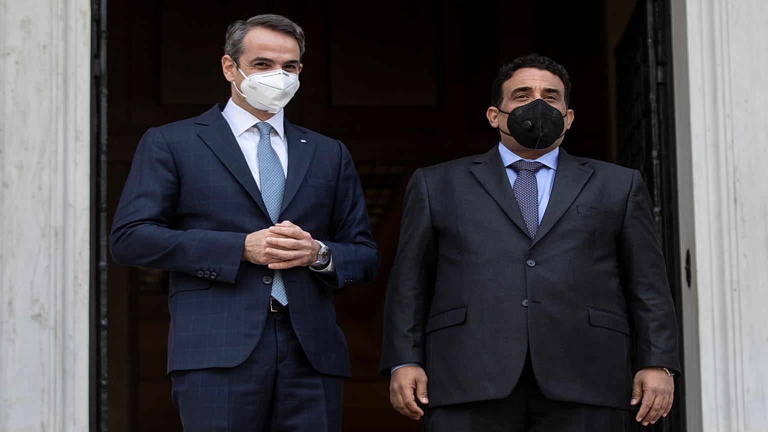 رئيس الوزراء اليوناني كيرياكوس ميتسوتاكيس إلى جانب رئيس المجلس الرئاسي الليبي محمد المنفي