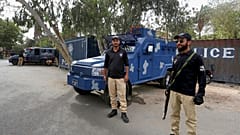 Des policiers gardent une route bloquée par des conteneurs maritimes, à proximité du consulat de France, à Karachi, au Pakistan, jeudi 15 avril 2021.