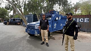 Des policiers gardent une route bloquée par des conteneurs maritimes, à proximité du consulat de France, à Karachi, au Pakistan, jeudi 15 avril 2021.