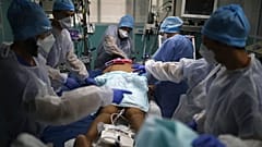 a medical crew gathers around a patient affected with COVID-19 in a Marseille hospital, southern France