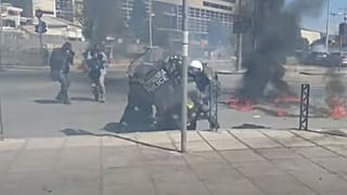 Αστυνομικοί επιχειρούν να σβήσουν φωτιά από μολότοφ σε διαδηλωτή