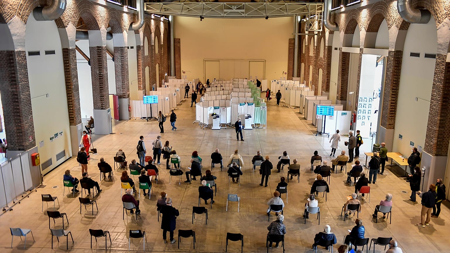 People wait at a vaccination center in Milan, Italy, Friday, April 16, 2021.