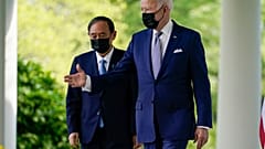 President Joe Biden, accompanied by Japanese Prime Minister Yoshihide Suga, walks from the Oval Office to speak at a news conference in the Rose Garden of the White House.