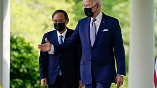 President Joe Biden, accompanied by Japanese Prime Minister Yoshihide Suga, walks from the Oval Office to speak at a news conference in the Rose Garden of the White House.