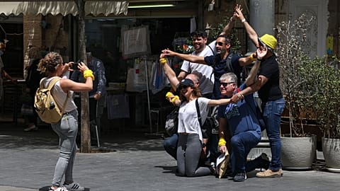 People pose for a picture on a street in Jerusalem after Israeli authorities announced that face masks were no longer required outdoors.