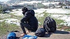 A man dries his belongings outside the Miral refugee camp in Velika Kladusa, Bosnia, in early April 2021
