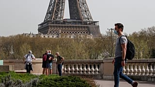 A man wearing a mask crosses the Bir Hakeim bridge in Paris, Thursday, April 1, 2021.