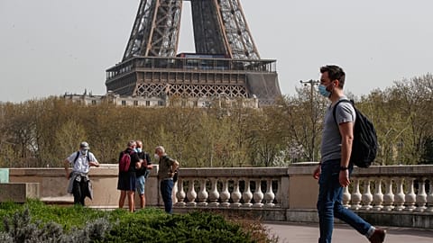 A man wearing a mask crosses the Bir Hakeim bridge in Paris, Thursday, April 1, 2021.