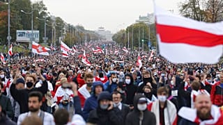 People with old Belarusian national flags march during an opposition rally to protest the official presidential election results in Minsk, Belarus, Sunday, Sept. 27, 2020.