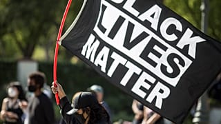A demonstrator holds a Black Lives Matter flag outside Los Angeles Mayor Garcetti's house after a guilty verdict was announced at the trial of former Minneapolis police Office